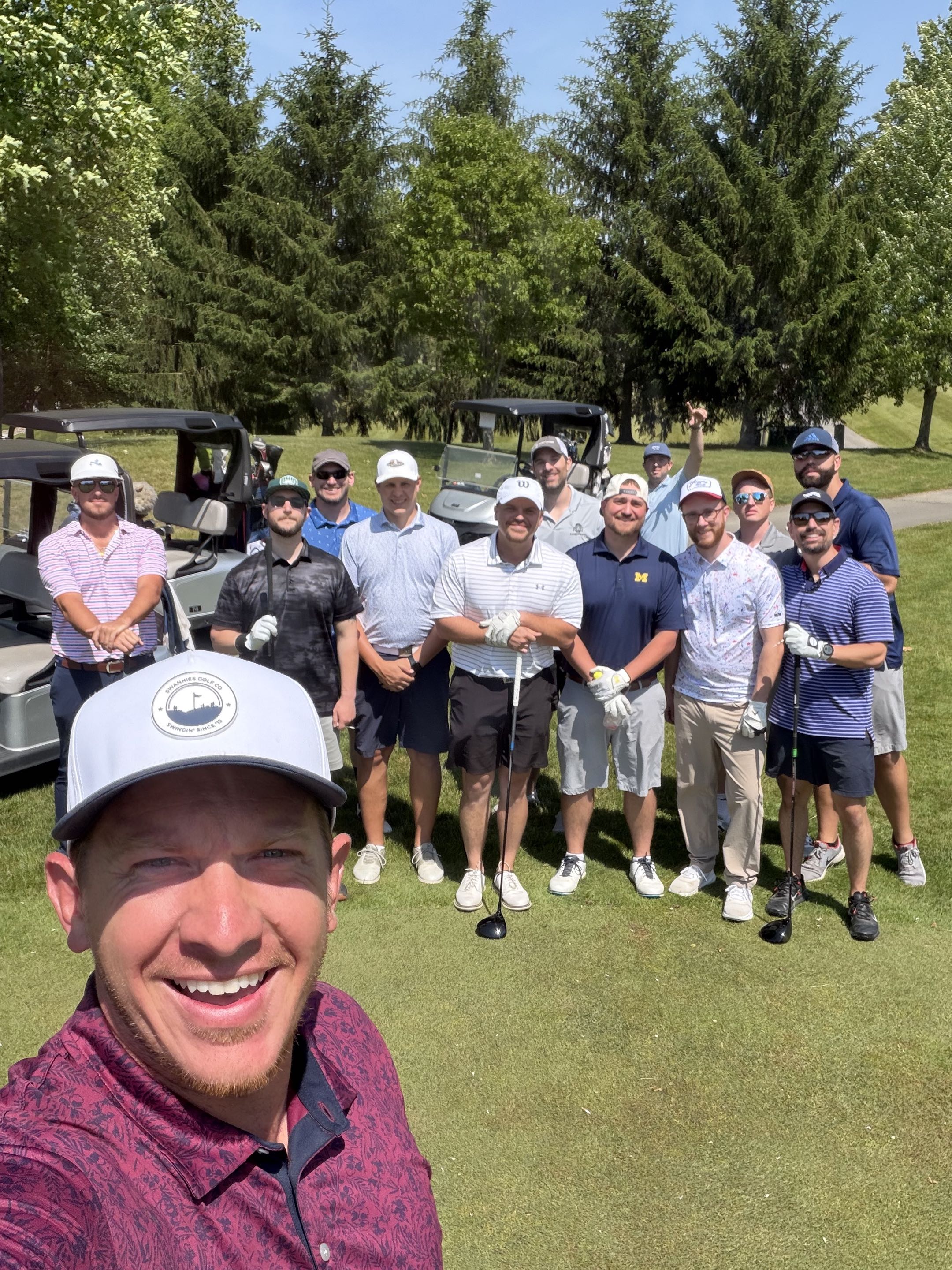 The June boys-weekend group gathered on the tee box